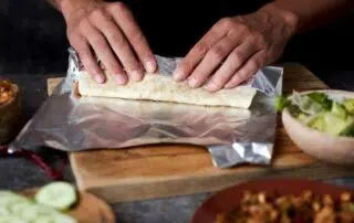 man preparing a burrito