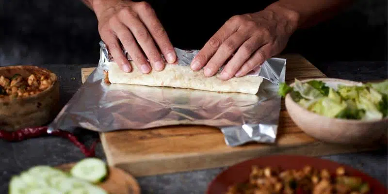 man preparing a burrito